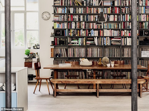 This open-plan dining room/kitchen is lined with floor-to-ceiling bookshelves, which add height and depth to the space