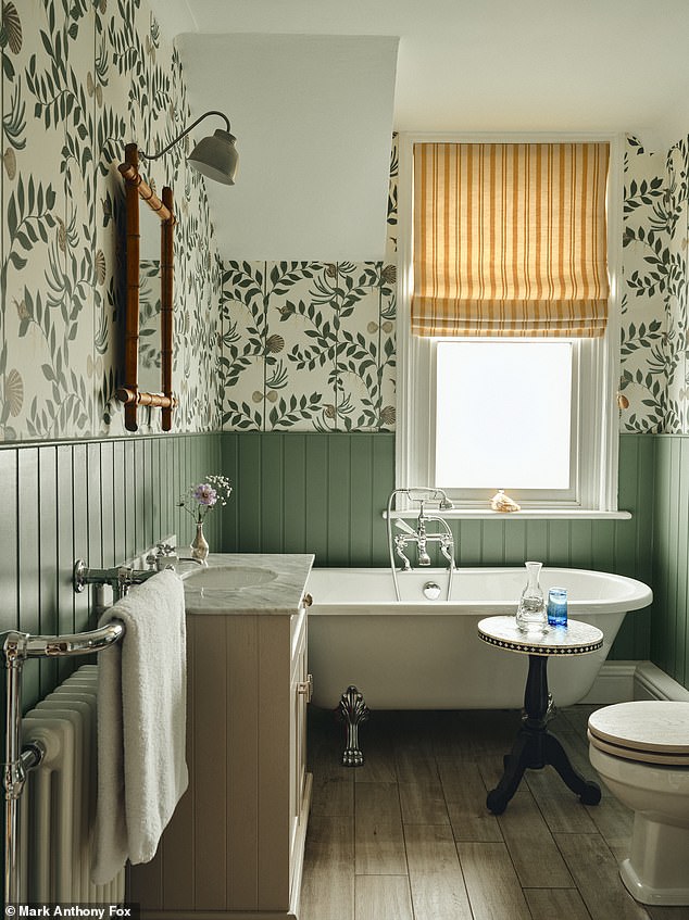 The family bathroom is adorned with a vintage bamboo mirror sourced on Ebay and a side table bought on Facebook Marketplace. The fabric for the yellow blind was a remnant from Haines Collection