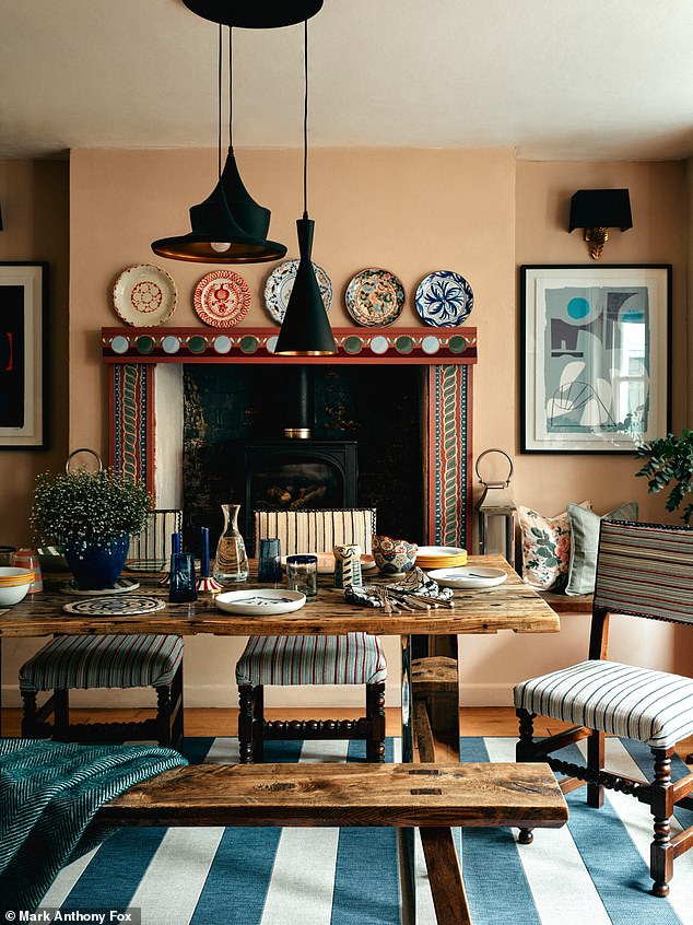 The striking upcycled fireplace was painted by the artist Josephine Blanchard using old Edward Bulmer Natural Paint samples (edwardbulmerpaint.co.uk). Plates above it have been collected from charity shops over the years. The table is made from old railway sleepers