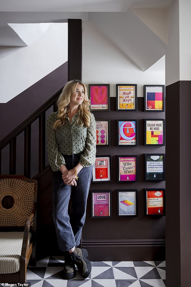 The hallway¿s mandarinstone.com floor tiles complement the dark two-tone walls. ¿They were originally painted in two textures, and I wanted the same vibe.¿ The prints are taken from a book she loves by the artist Harland Miller