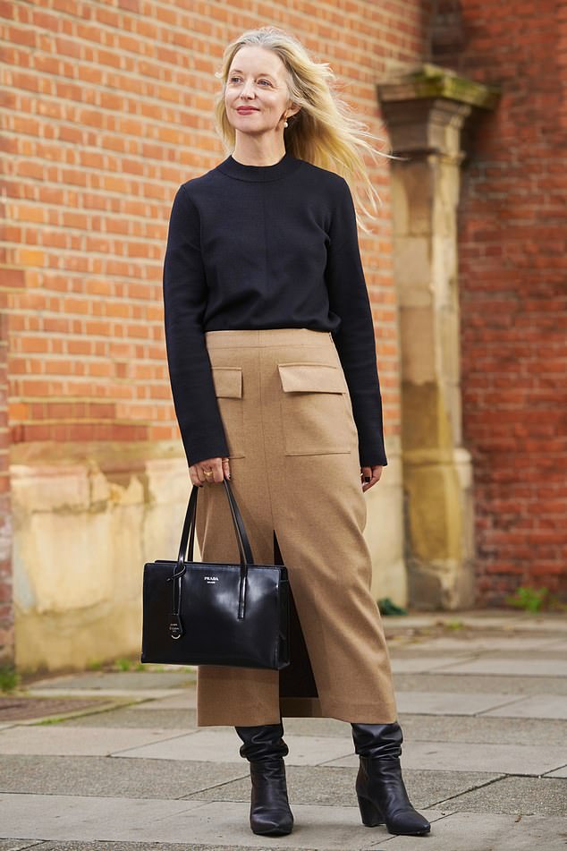 Joanne Hegarty wears a cashmere knit by Cos with a skirt by Massimo Dutti. Her bag and boots are both Prada