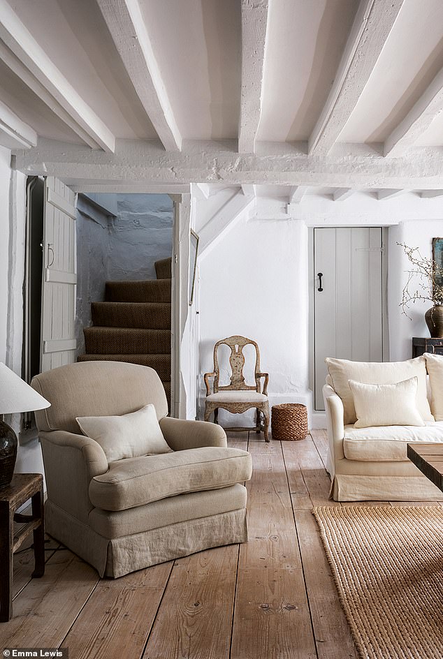 In the sitting room, where a staircase leads up to the guest suite, elegant white fabrics work perfectly with an antique-linen-covered Swedish chair and a low rope stool. Vintage cheeseboard floors harmonise with a sisal rug. Browse a wide range of vintage furniture at 1stdibs.com